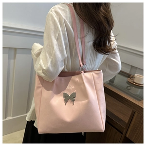 Détail du sac cabas rose avec décoration papillon en métal liquide sur un mannequin