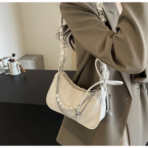 Détail de la chaîne de perles sur le sac à bandoulière blanc plissé avec fermeture éclair
