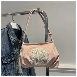Detail of pink embroidered shoulder bag with floral pattern and elegant long tassel