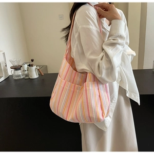 Close-up of colorful striped canvas tote bag with front pockets and pleated texture