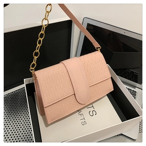 Détail du sac à bandoulière rose avec gaufrage triangulaire et chaîne dorée