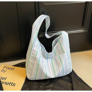 Detailed texture of purple and green striped nylon fabric on a large casual hobo bag