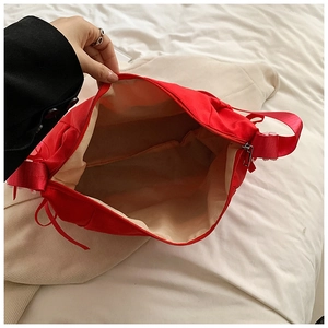 Top view of red nylon crescent bag showing spacious interior compartment and lining
