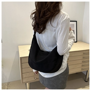 Close-up van een zwarte nylon hobo tas met een minimalistisch halve maan ontwerp