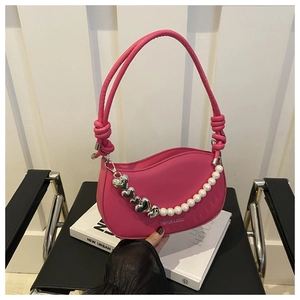 Detail of fuchsia shoulder bag with pearl chain, heart pendant and knotted strap