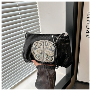 Detail of Chinese style embroidered floral patch on black pleated satin handbag