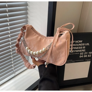 Détail du sac plissé rose avec breloques en perles et bandoulière chaîne argentée