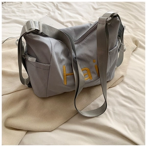 Detailed view of high-density canvas tote with yellow Hai letter embroidery and adjustable strap