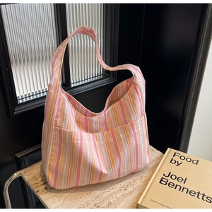 Detail of colorful striped tote bag with seersucker texture and front pocket design