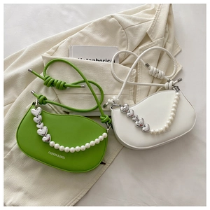 Detail of color-block crescent bag with pearl and silver heart decorative chain strap