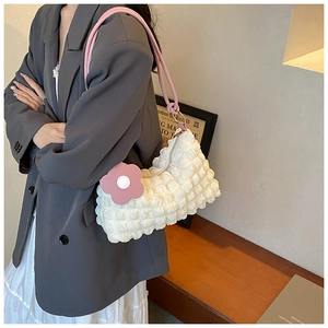 Detail of white bubble texture fabric shoulder bag with pink strap and floral tag