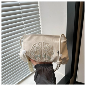 Detailed embroidery and silky fabric of an elegant beige Chinese style shoulder bag