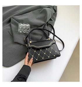 Detail of black leather handbag with heart embroidery and gold wave stitching