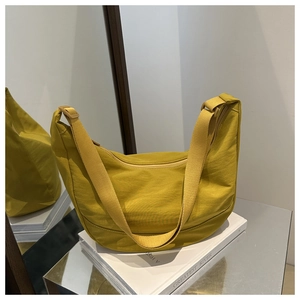 Detailopname van de mosterdgele nylon hobo tas met verstelbare brede stoffen band