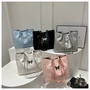 Détail de cinq sacs cabas élégants en cuir métallisé avec boucles en forme de papillon