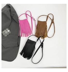 Close-up of tassel crossbody bags in rose red, brown, and black with metallic buckles