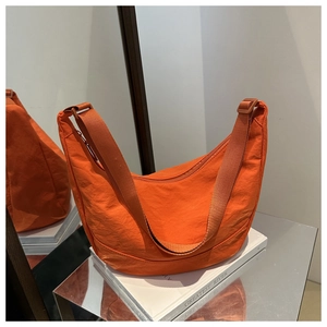 Detail van helder oranje nylon halve maan tas met verstelbare riem en ritssluiting
