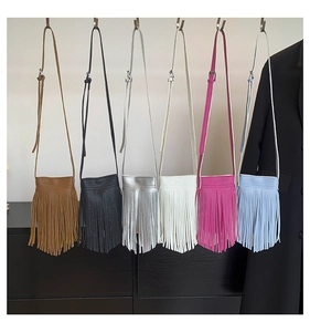 Close-up of tassel detail on small vertical crossbody bags in multiple vibrant colors