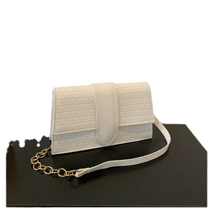 Sac bandoulière blanc minimaliste avec texture géométrique et bandoulière chaîne dorée