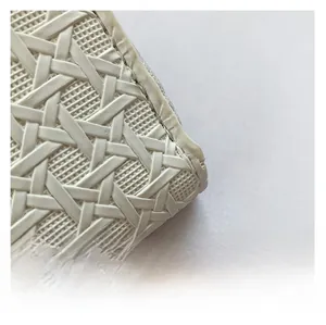 Detailed macro view of the woven white leather texture and stitching on the women's clutch bag