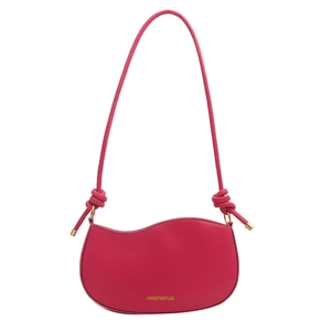 Magenta wave-shaped crossbody bag with decorative knots and golden logo on white background