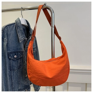 Detailweergave van levendige oranje halvemaanvormige tas van getextureerd waterdicht nylon