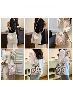 Détail d'un sac à bandoulière à imprimé papillon avec glands décoratifs en diverses couleurs
