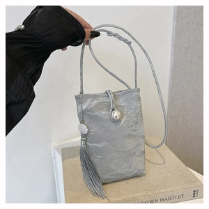 Detail of silver phone bag with pleated fabric, pearl clasp, and long elegant silk tassel