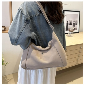 Lifestyle view of a large apricot canvas tote bag shown worn on a model's shoulder