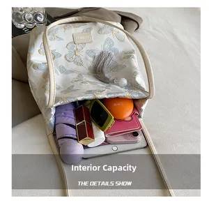 Vue détaillée de l'intérieur spacieux de ce sac brodé avec pompon et divers objets