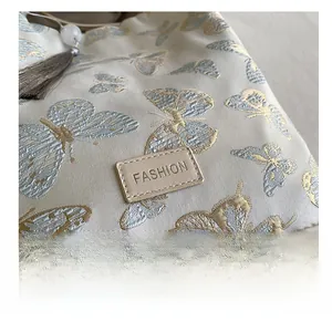 Gros plan d'un sac en jacquard avec motif papillon bleu et écusson en cuir de mode