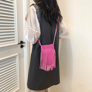Fuchsia tassel crossbody bag with large capacity for casual everyday wear on female model