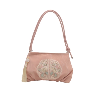 Sac à main rose de style chinois avec broderie florale et pompon sur fond blanc