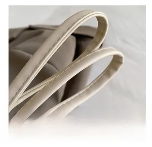 Vue détaillée des doubles bretelles confortables avec coutures régulières sur un sac crème
