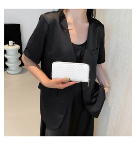 Close-up of white woven long clutch wallet featuring gold-tone zipper details