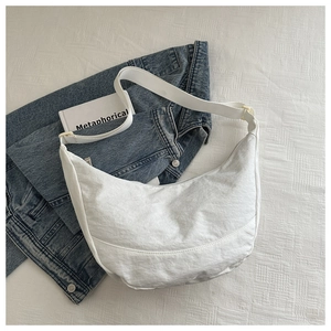 Witte halve maan tas van Oxford stof op een blauwe denim jas voor een trendy look