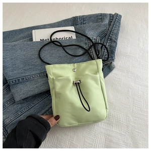 Vue à plat d'un sac bandoulière minimaliste vert menthe avec cordon et fermoir aimanté