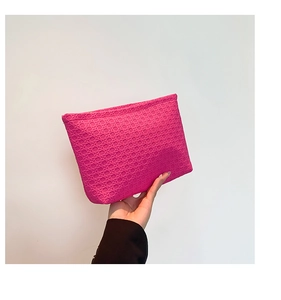Detail of rose pink envelope clutch featuring 3D woven texture and zipper closure