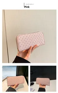Detailed macro view of pink long wallet with textured woven pattern and metal zipper closure