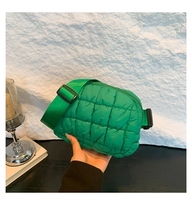 Détail du sac bandoulière matelassé vert montrant les coutures carrées et le nylon