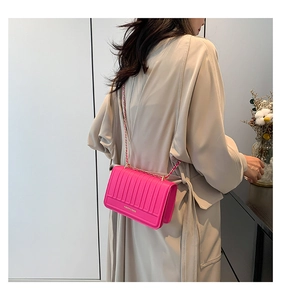 Detail of fuchsia quilted crossbody bag with golden chain strap and fashion logo