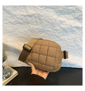 Détail du sac bandoulière en nylon matelassé kaki avec coutures carrées et sangle large