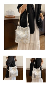 Détail du sac cabas blanc avec broderie papillon bleue et un élégant gland gris