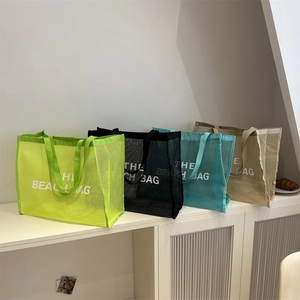 Minimalist mesh beach tote bags with The Beach Bag print in green, black, blue, and beige