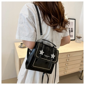 Detail of vintage black star leather backpack with silver studs and metal branding
