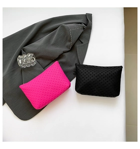 Detail of woven texture on pink and black envelopes with smooth zipper closures