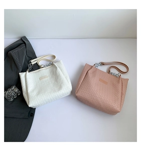 Detail of woven texture tote bags with silver chain straps and fashion label accent