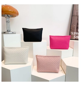 Detailed close-up of colorful envelope clutch bags with woven texture and gold zippers