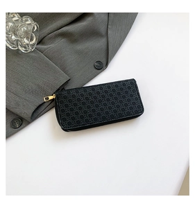 Detailed view of black woven texture on PU leather wallet with gold metal zipper