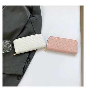 Close-up of woven texture on cream and pink long zip wallets for women with gold hardware
